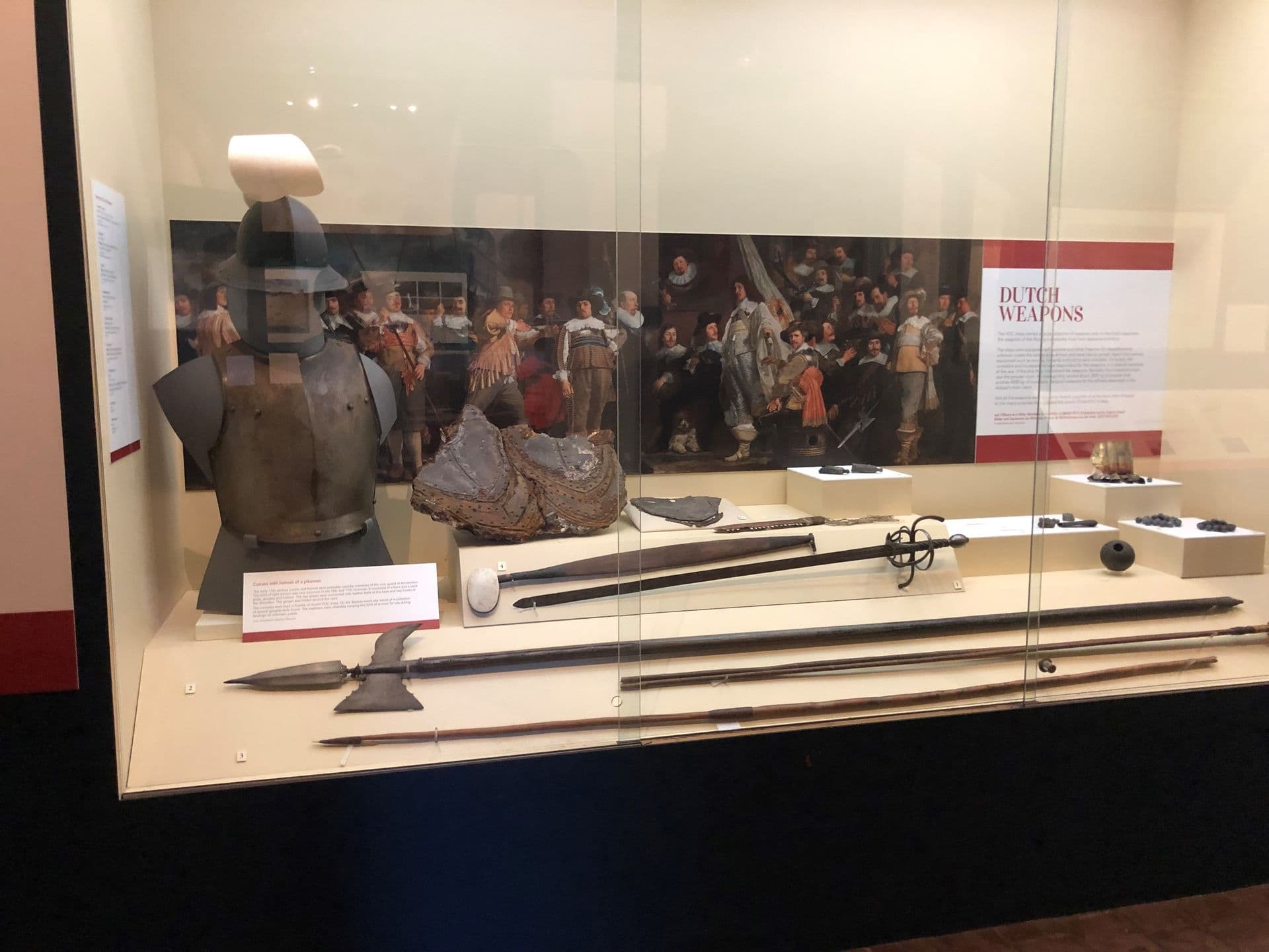 Dutch armour, helmet and weapons, displayed with Aboriginal spears and other weapons.