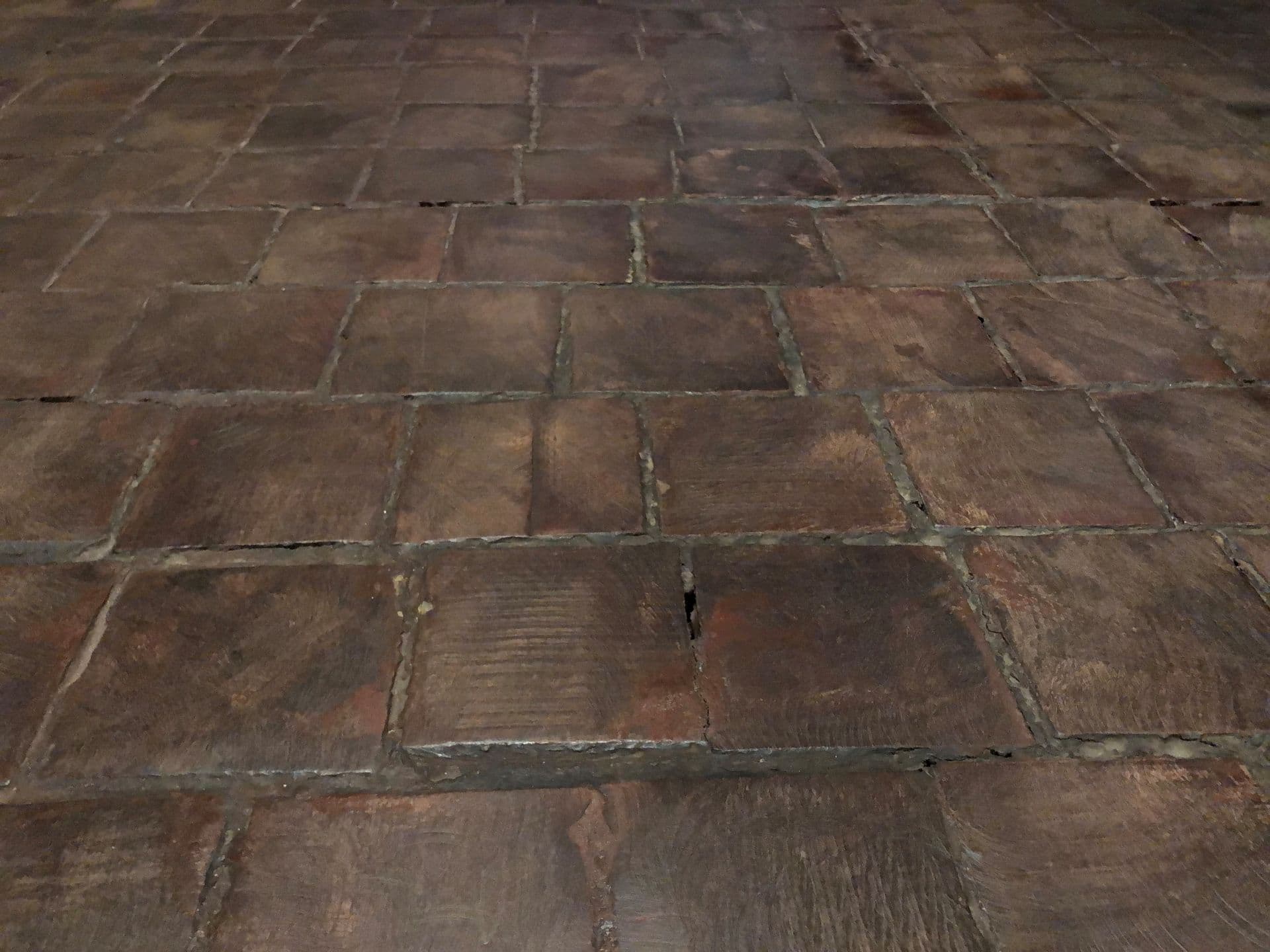 Smooth, square, pieces of wood are laid like tiles on the gallery floor.