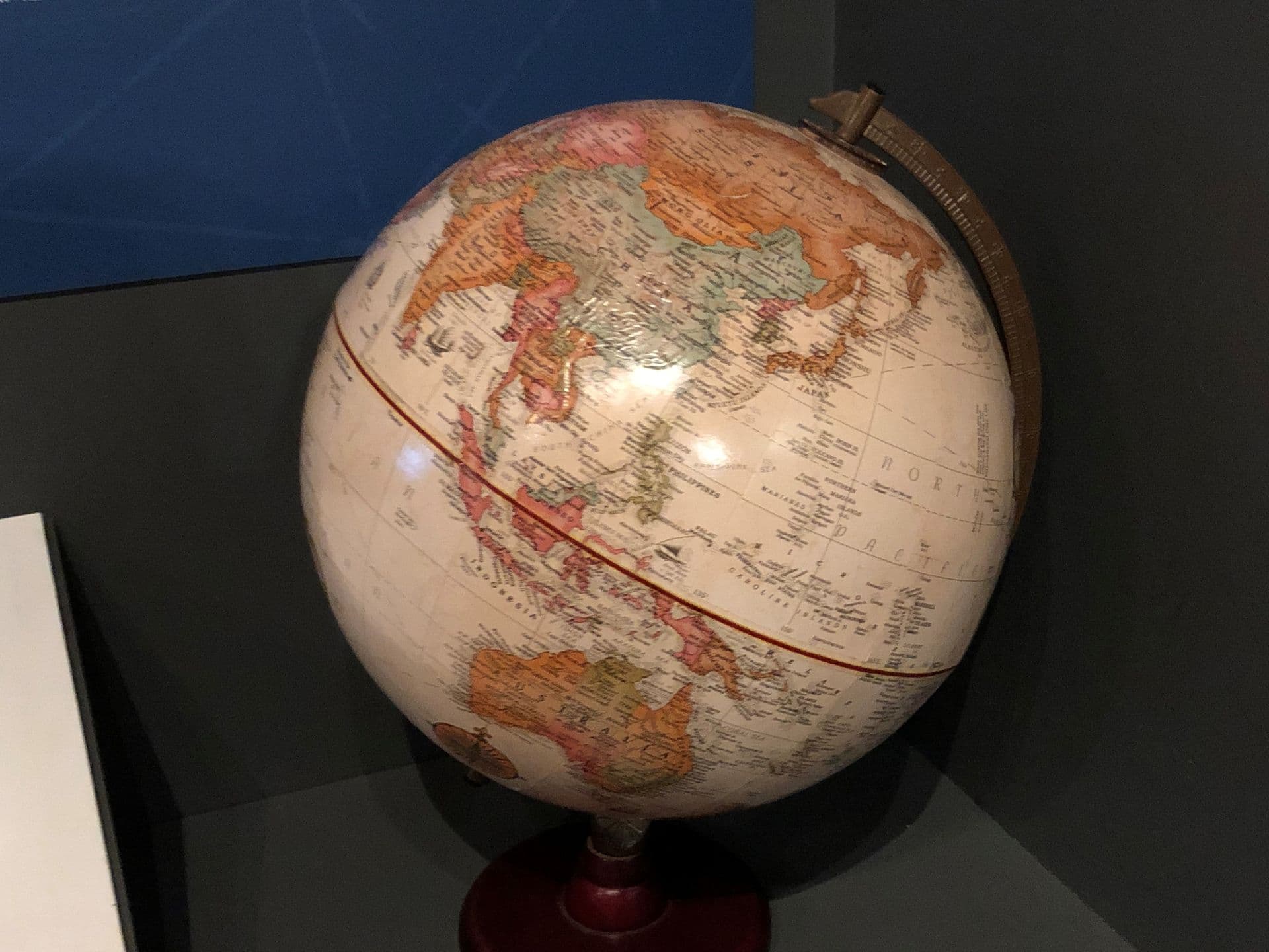 Round ball mounted on a stand with images of countries of the world printed on it.