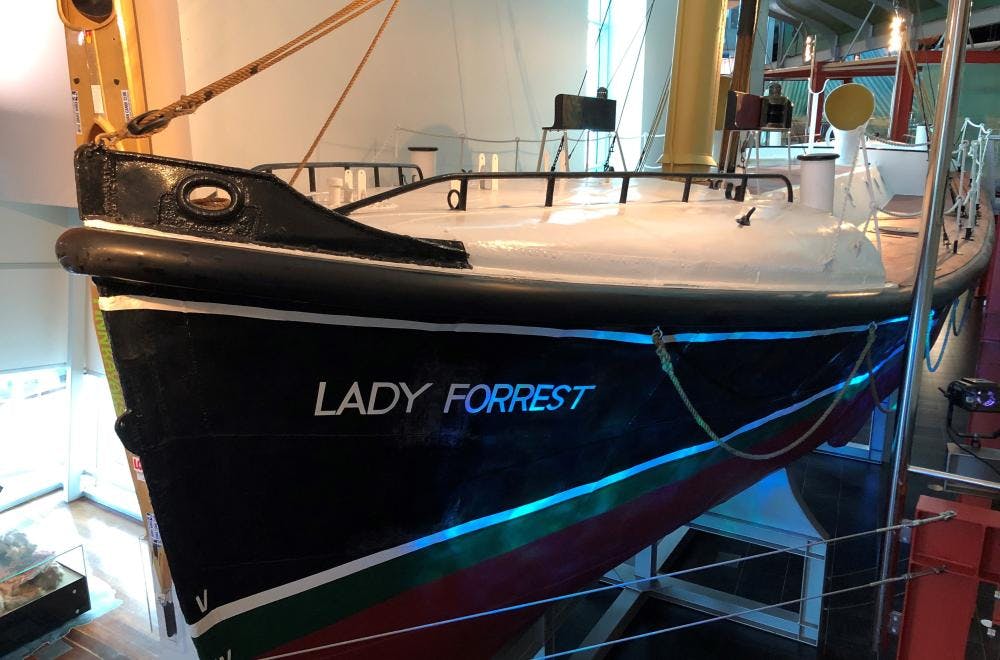 The red and black hull of the Lady Forrest is suspended next to the walkway.