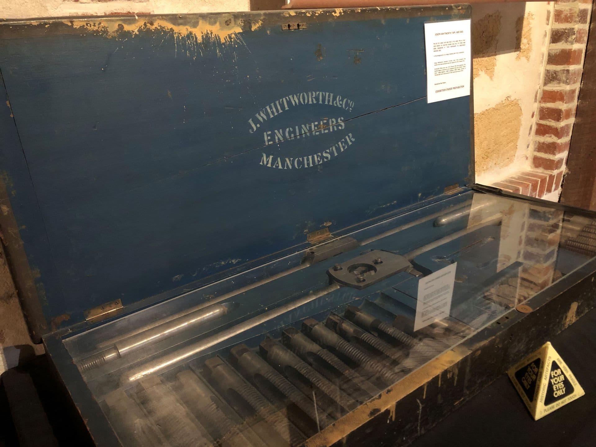 Open box with inside lid inscribed with "J Whitworths & Co Engineers Manchester, and inside shows rows of metal rods of different sizes.