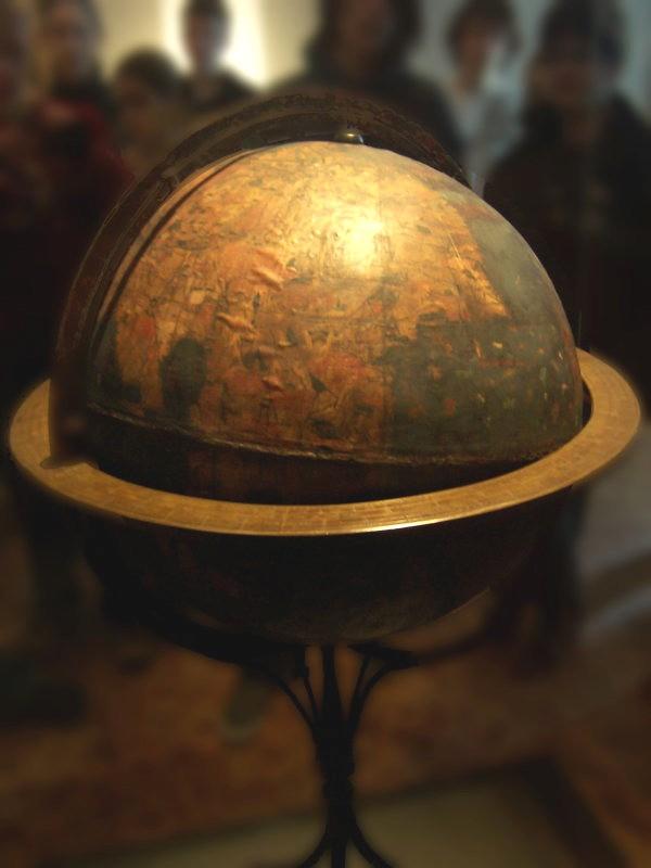 Round ball mounted on a stand with images of countries of the world known at that time painted on it.