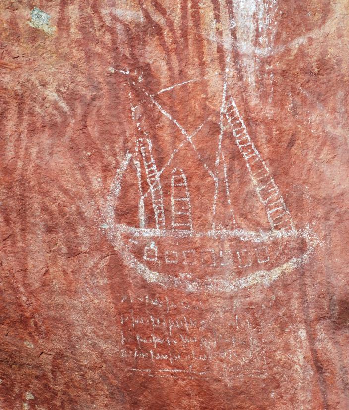 Drawing in white colour on red coloured rock of a ship.